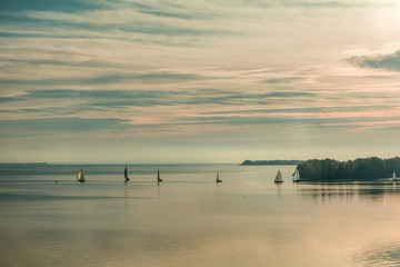Naklejka premium Sunrise over the river with yachts on a calm water surface