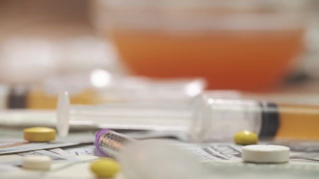 Spoon with cocaine, medicine pills on dollar bank notes. Macro shoot