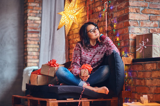 Brunette female in a room with Christmas decoration.