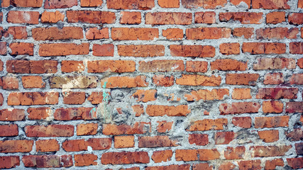 Brick wall made of red stone background. The spoiled brick is vintage.