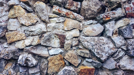 Stone old wall from huge blocks. Background of stones. The concept of reliability. The space between the stones is filled with cement.