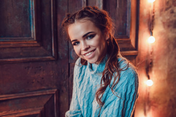Fototapeta premium Portrait of a beautiful woman in a blue sweater. Christmas. New Year.