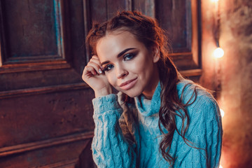 Fototapeta premium Portrait of a beautiful woman in a blue sweater. Christmas. New Year.