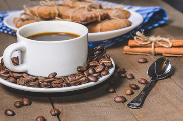 Black coffee in a white cup on a blue napkin and homemade cookies.