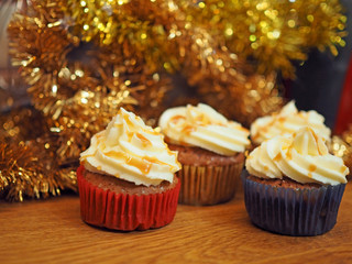 Christmas chocolate muffins with caramel on the background of Christmas decorations with serpentine