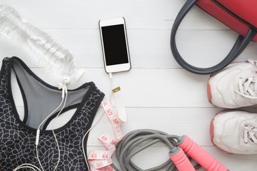 Overhead view, Creative flat lay of Healthy or Beauty concept with sport bra, shoes, measuring-tape and mobile phone on wooden background