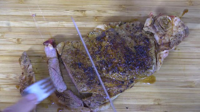 Overhead view of slicing a rib steak, 4k
