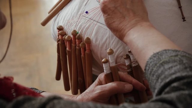 Close-up of woman hands works with bobbin lace, hand made crafting Laces, toned
