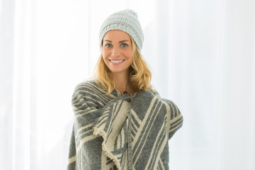 beautiful woman trying new wolly hat at home