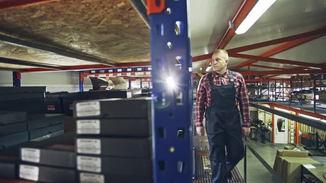 Man passing by the shelves in storehouse