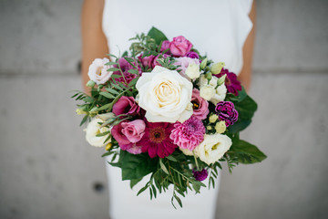 wedding bouquet with big rose in the hand of a bride