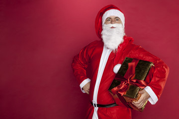 Santa Claus with a gift in his hand, copy space next to him