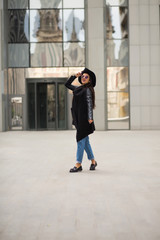 Stylish dressed young woman walking near the city mall