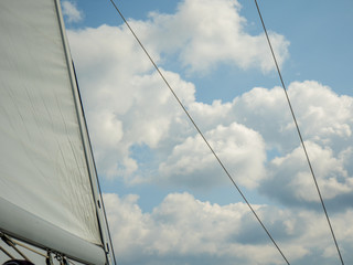 Sailing boats sails with clouds in background.