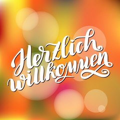 Herzlich willkommen. Welcome. Traditional German Oktoberfest bier festival . Vector hand-drawn brush lettering illustration on orange blurred background