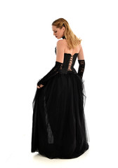 Fototapeta premium full length portrait of a blonde girl wearing black gothic gown. standing pose, isolated on white background.