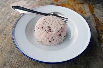 Steamed rice with chopsticks on wooden table