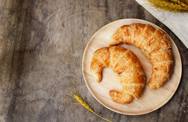 freshly baked croissants on wooden cutting board, top view