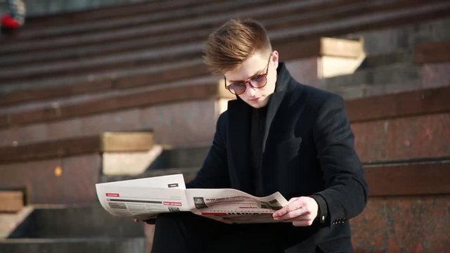 A young Man reads a nationalist Newspaper 'Nation' on the Street of Kiev Ukraine