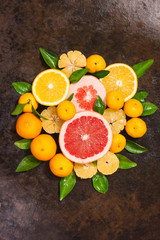 Fresh citrus fruit assortment. Different citrus fruit on black slate table. Fruit food background. Healthy eating and diet.