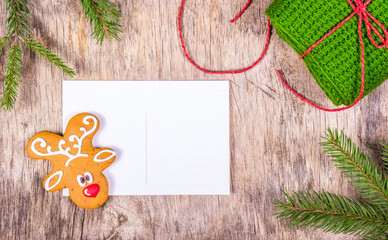 Christmas background with fir tree and blank greeting card. Preparing for Christmas. Painted gingerbread and  knitted gift. Copy space