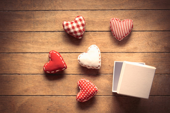 Heart shape toys and gift box on wooden background