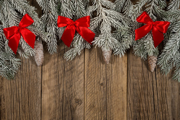 The branch of spruce in the snow on a dark wooden table.