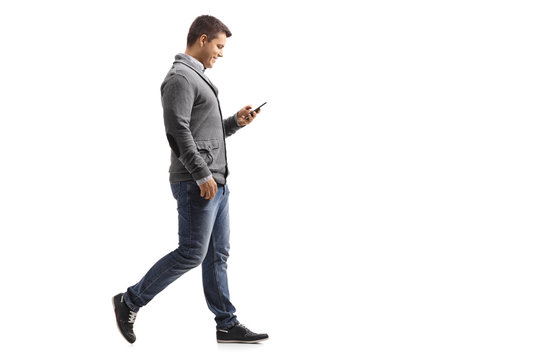 Young Man Walking And Using A Phone