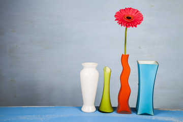 Multicolored vases and pink gerbera