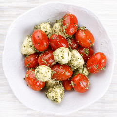 Caprese salad with pesto.  Mozzarella cheese and cherry tomatoes with pesto sauce.