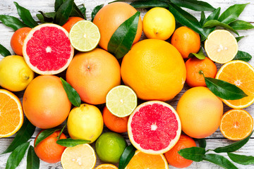Citrus fruits background. Assorted fresh citrus fruits with leaves. Orange, grapefruit, lemon,...