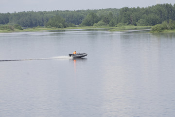 manages gray inflatable rubber boat with an outboard motor