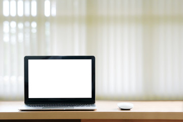 blank screen laptop on the desk on background blur of curtain window.copy space.