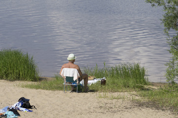 Young couple laying on sandy beach at sea shore in sunny day