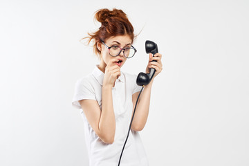 Young beautiful woman in glasses on a white isolated background holding a phone