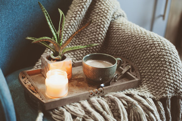 cozy winter morning at home. Hot cocoa or coffee with candle on blue nordic style chair 