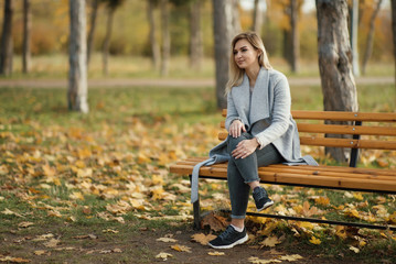 Naklejka na ściany i meble young beautiful woman in park. Autumn background 