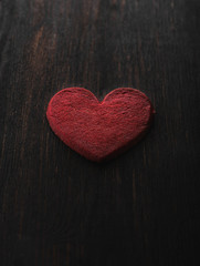 Red heart symbol on the brown wood background. 
