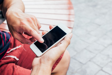 Close up of men hands holding touching mobile phone with blank copy space for your text message in cafe with light Sunset,Vintage tone.Selective focus