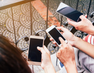 Close up of men and woman hands holding touching mobile phone with blank copy space for your text message in cafe,Vintage tone.Selective focus