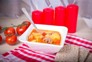 goulash soup with four red candles. advent