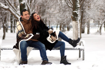 Fototapeta na wymiar A young couple walk in a winter park