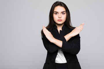 Woman showing a stop arms crossed on a gray background.