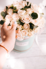 Ivory roses and eucaliptus bouquet in a round pastel blue colored box style arrangement.