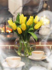 A bouquet of yellow tulips in a vase in the interior of a retro 