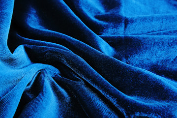 Silk dress material cloth texture pattern. Tailoring stitching concept. Shiny beautiful fashion fabric. Shiny clothing material sample.Creased fabric. Blue velvet.