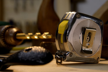 closeup of construction tools in the workshop with the tape measure in focus.
