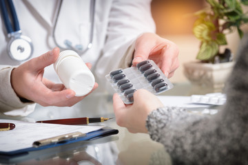 Doctor showing a pills to her patient