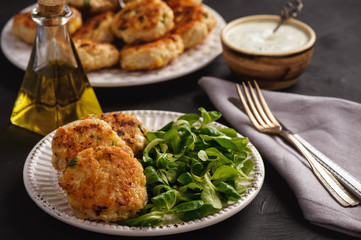 Chicken cutlets served with salad and garlic dip.
