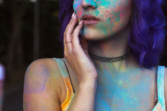 Crop portrait of sensual woman with purple hair covered with colorful Gulal powder